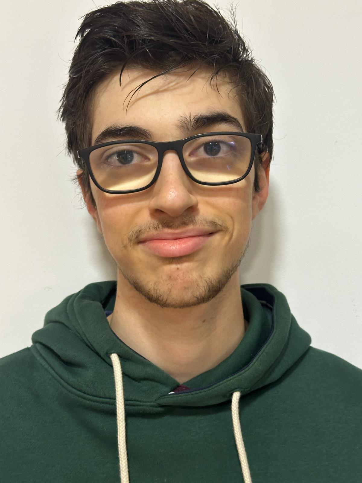 Joven con lentes y sudadera azul.